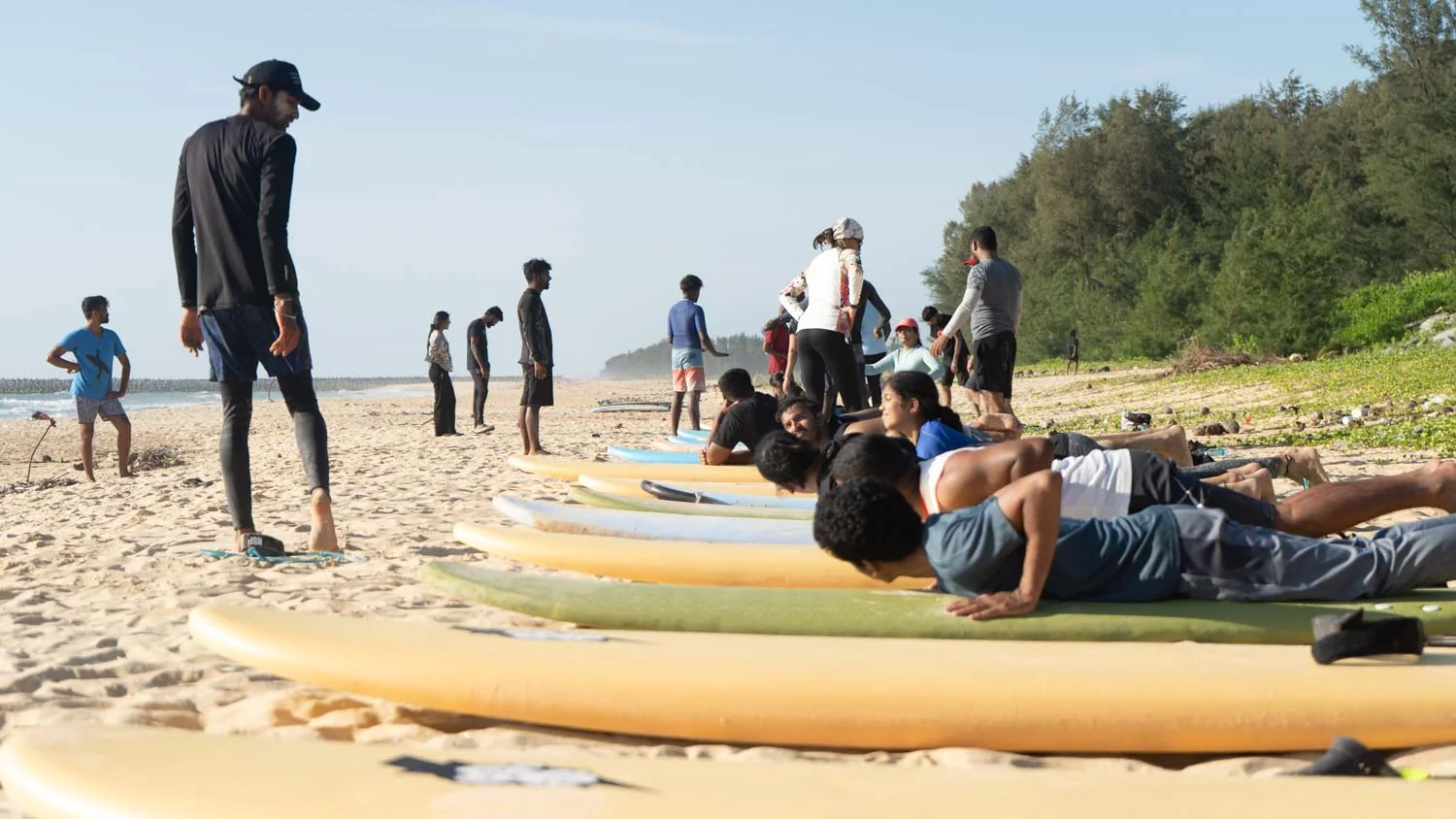Surf-school students and learner boards on the beach