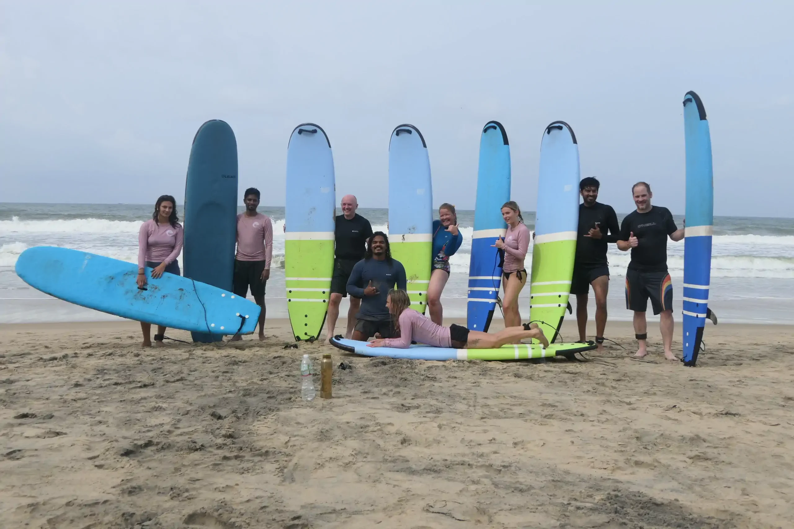 Surf instructor and learners entering the water with different surfboards