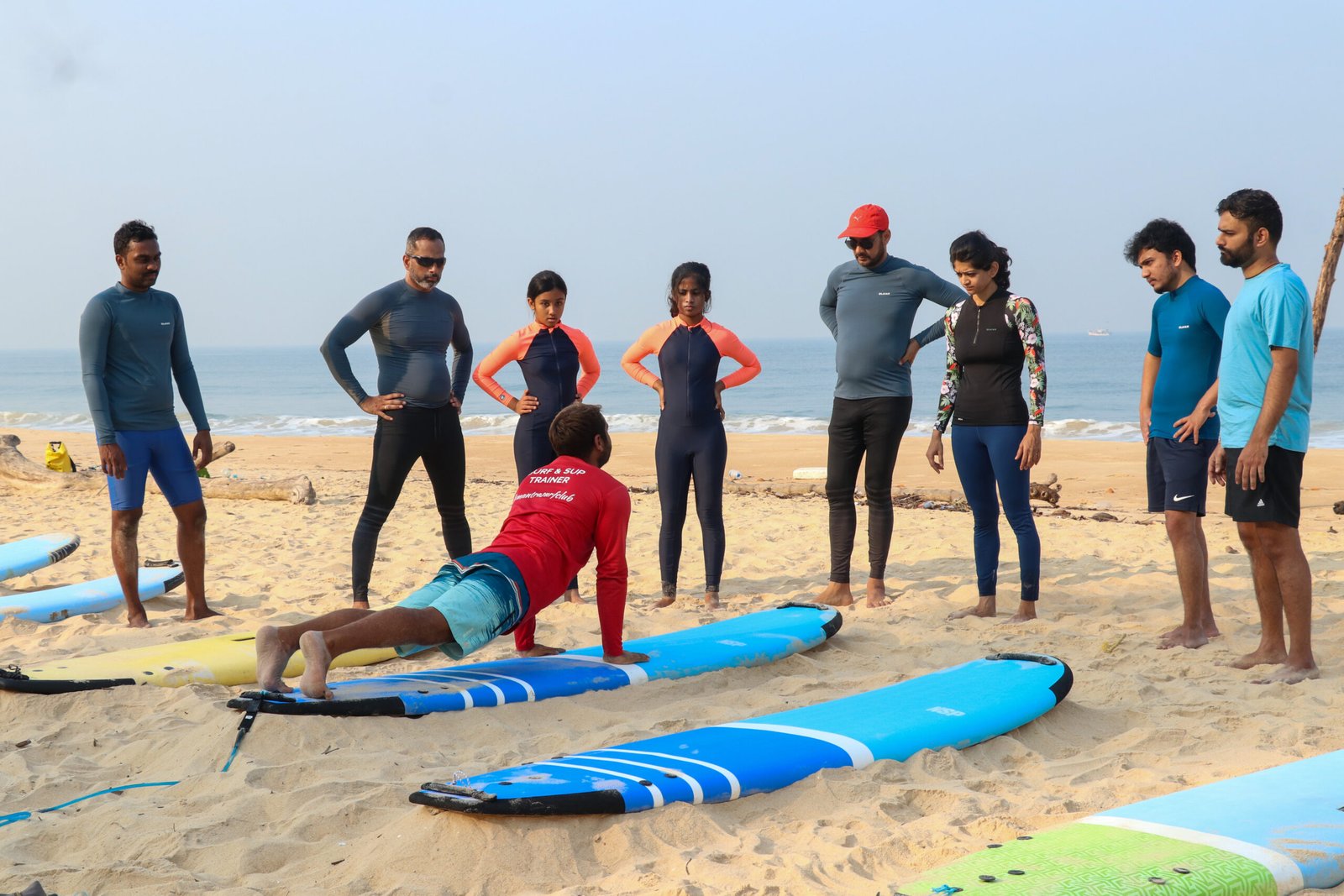 Surf instructor working with a group of people learning to surf