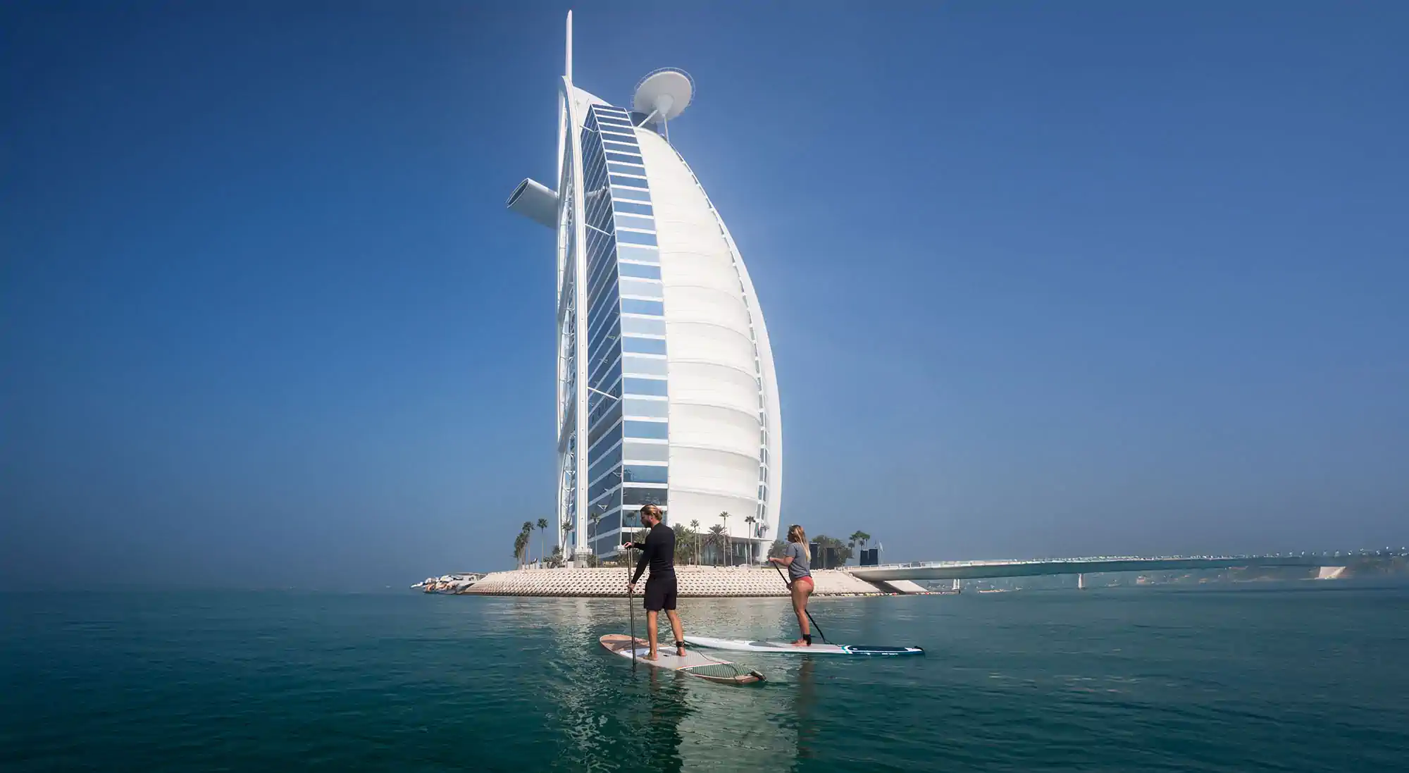 Paddleboarder crossing clear open water
